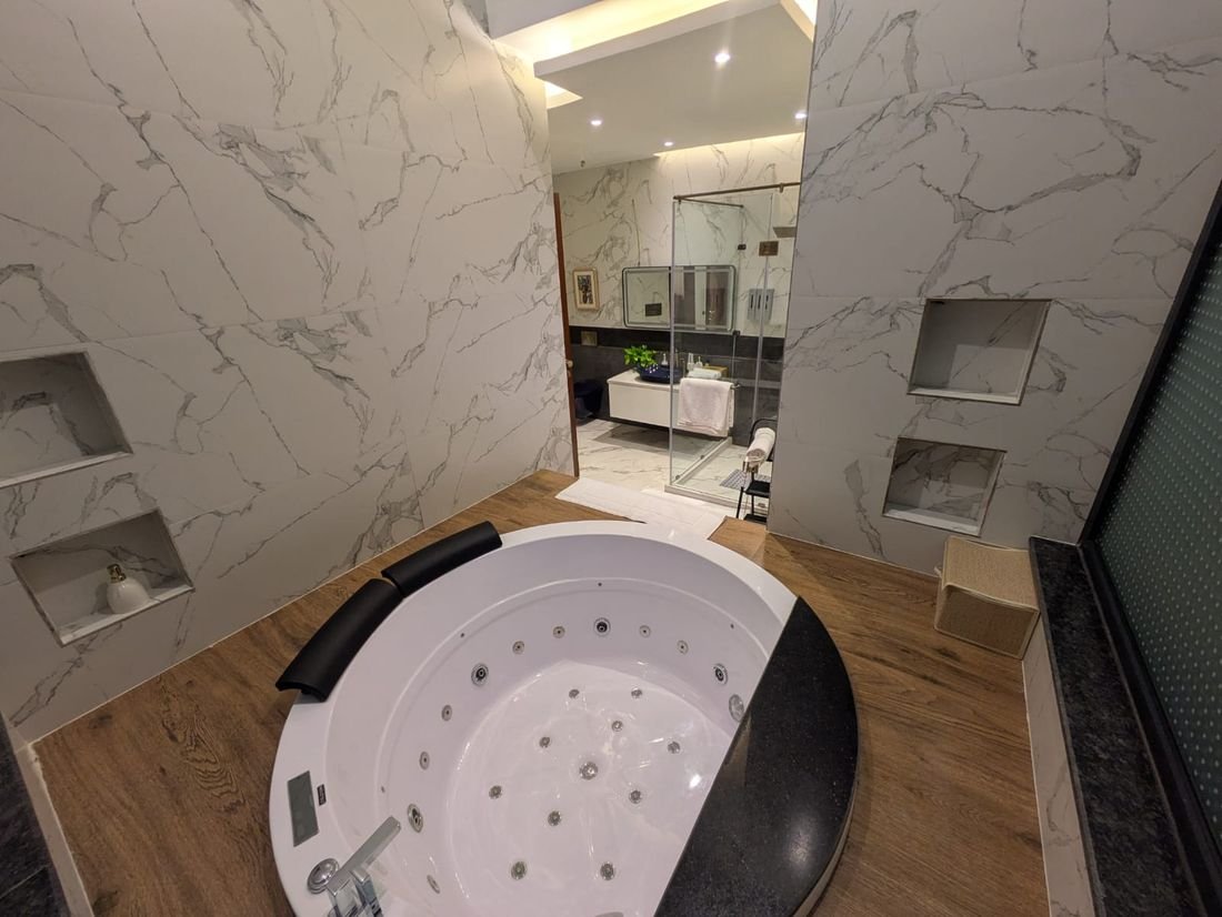 A marble en-suite bathroom with hydromassage tub at Palmwood Hills