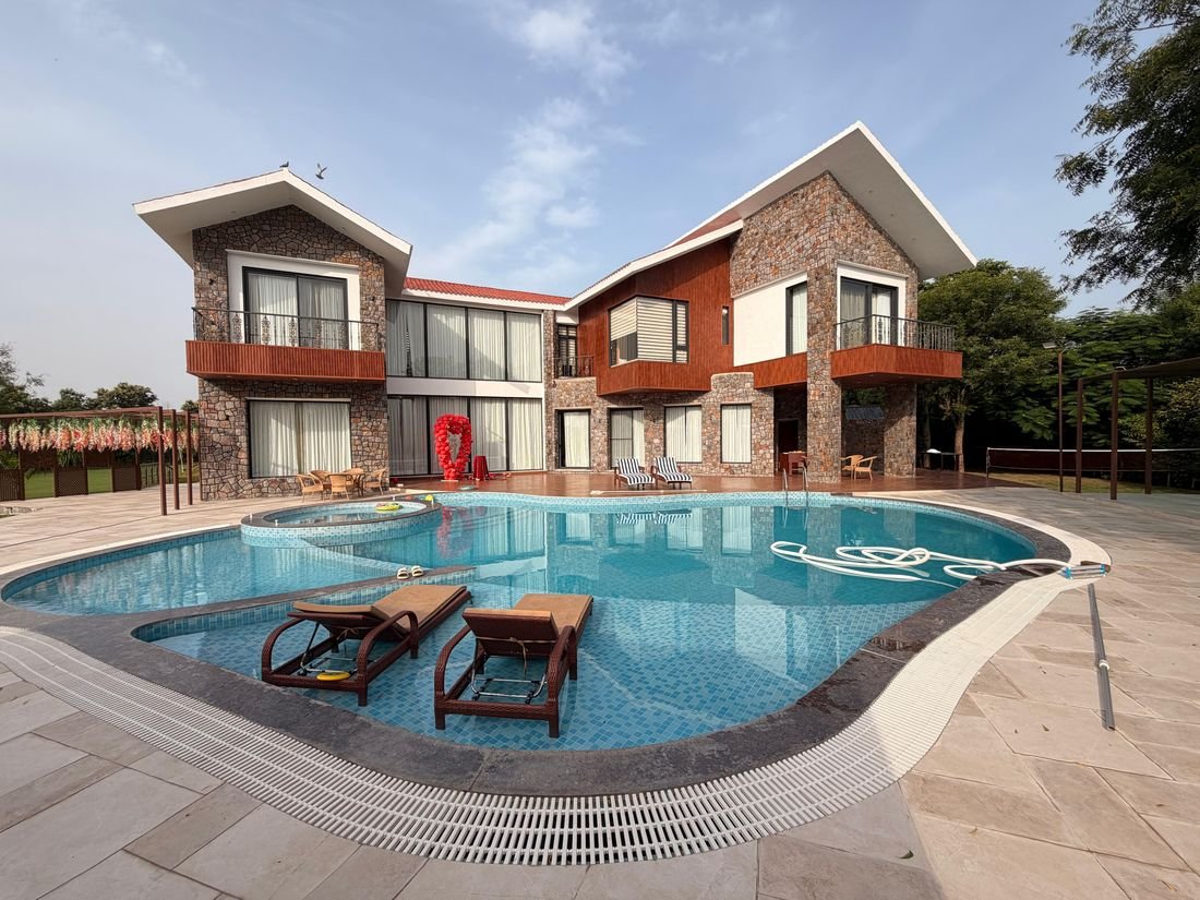 Palmwood Hills — the lagoon pool and stone villa on a two-acre private estate near Gurugram